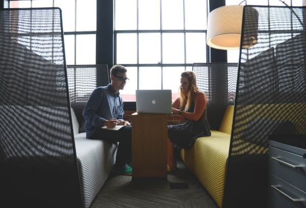 Two people collaborating with a laptop in a modern office space