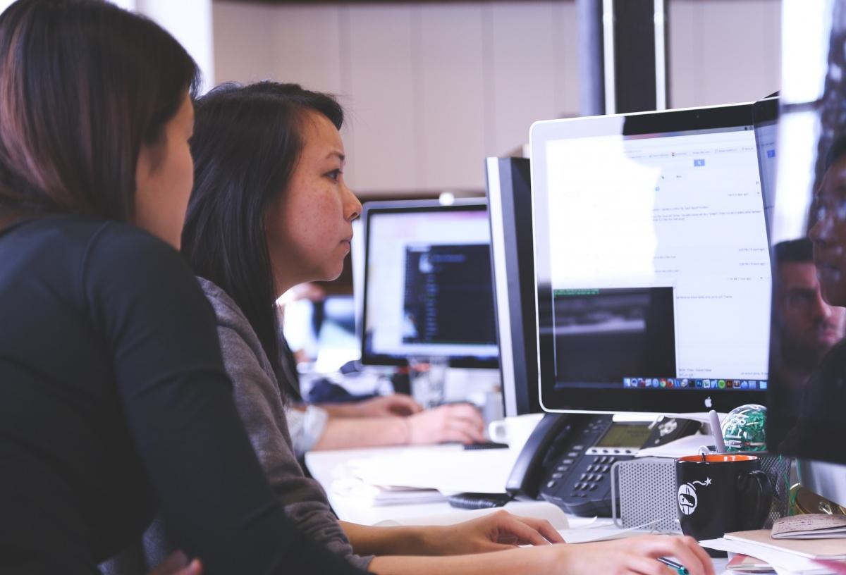 Two people working together on a computer.